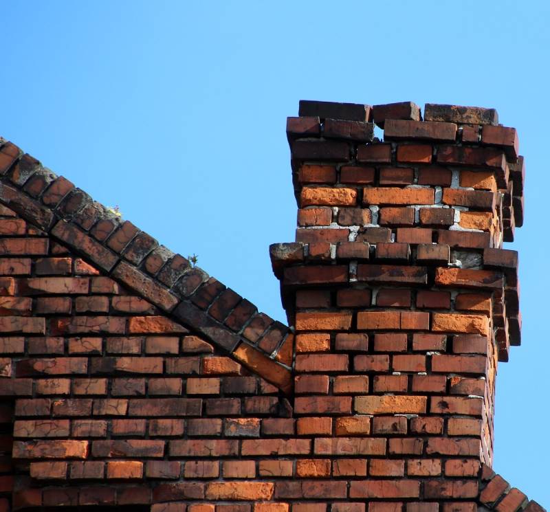 Damaged chimney on an Upton home showing cracks and missing mortar